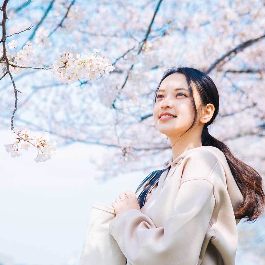桜の前にいる女性